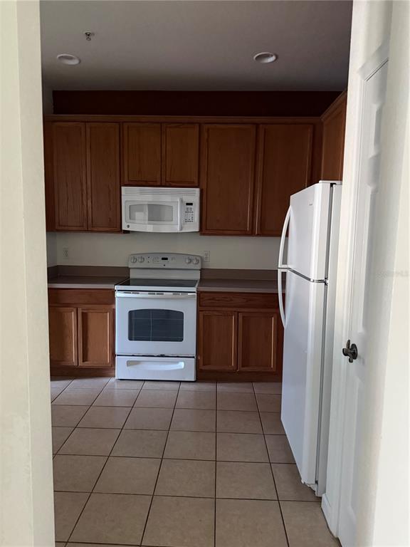 3051 Greystone Loop, Unit 304 Kissimmee, FL 34741 - Photo 8 of 32 a kitchen with cabinets and a refrigerator