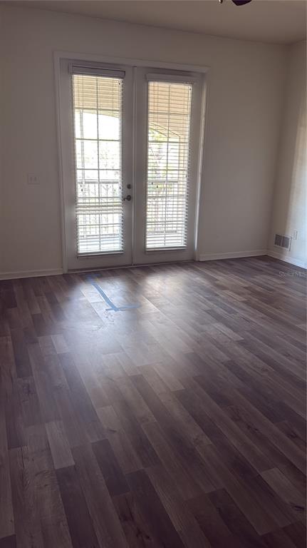 3051 Greystone Loop, Unit 304 Kissimmee, FL 34741 - Photo 10 of 32 an empty room with wooden floor and windows