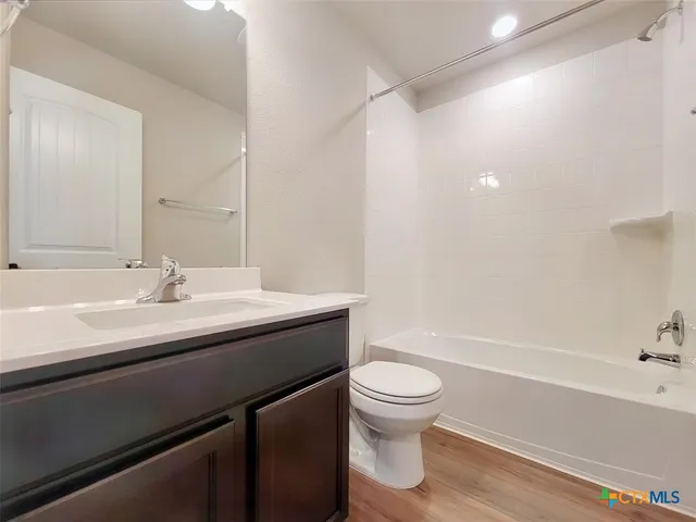 a bathroom with a toilet a sink a mirror and vanity