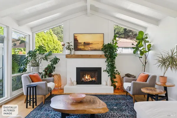 a living room with furniture potted plant a fireplace and a large window