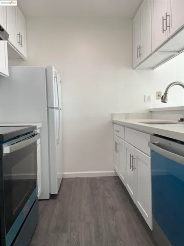 a kitchen with white cabinets and white appliances