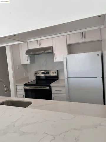 a kitchen with a refrigerator and a stove