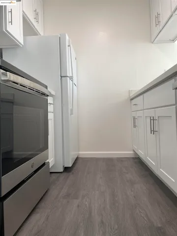 an empty room with wooden floor and white wall