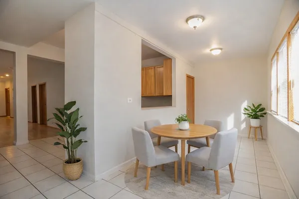 a dining room with furniture and potted plants