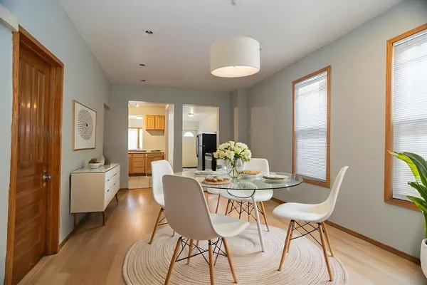 a view of a dining room with furniture a chandelier and wooden floor