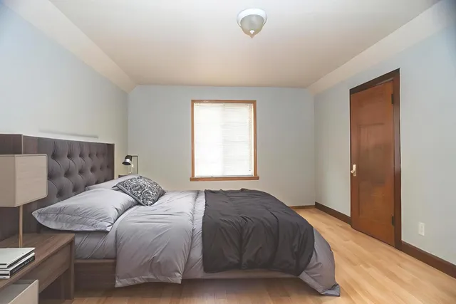 a bedroom with a bed and wooden floor