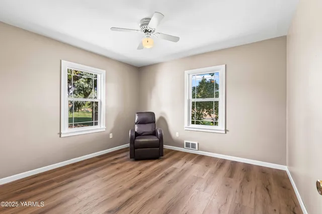 a view of room with window ceiling fan and hardwood floor