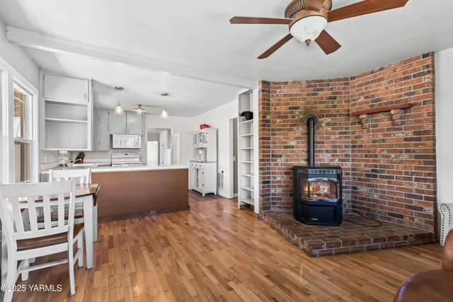 a view of kitchen with stainless steel appliances kitchen island hardwood floor and fireplace