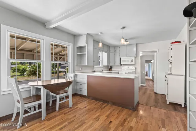 a kitchen with a table chairs refrigerator and windows