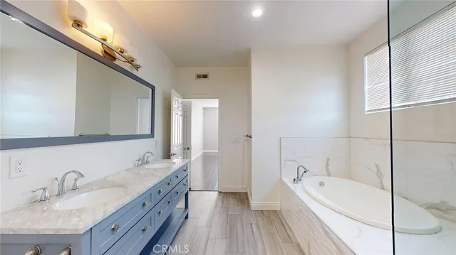 a bathroom with a granite countertop sink vanity and mirror