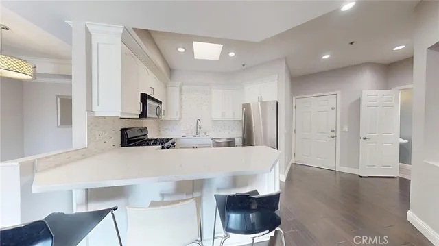 a kitchen with granite countertop white cabinets and white appliances