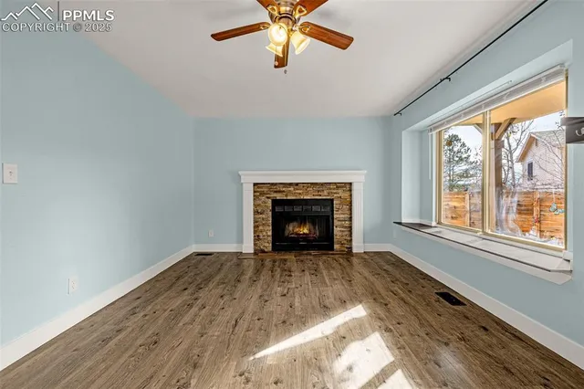 wooden floor fireplace and windows in an empty room