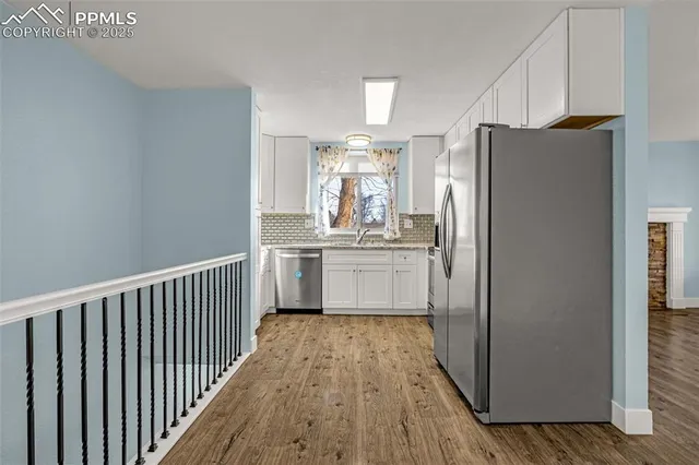 a kitchen with stainless steel appliances a refrigerator and a window