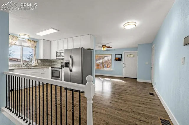 a kitchen with stainless steel appliances a refrigerator and wooden floor