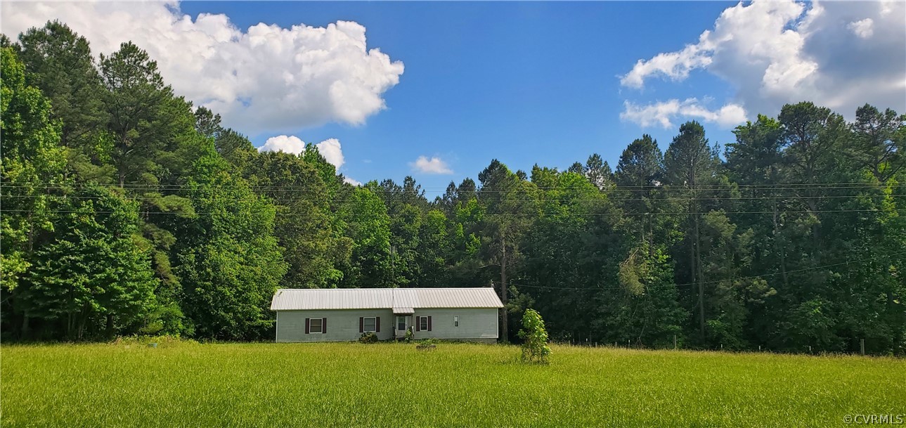 2564 Reedy Branch Road Brodnax, VA 23920 - Photo 1 of 6 a view of a white house in a big yard with large trees