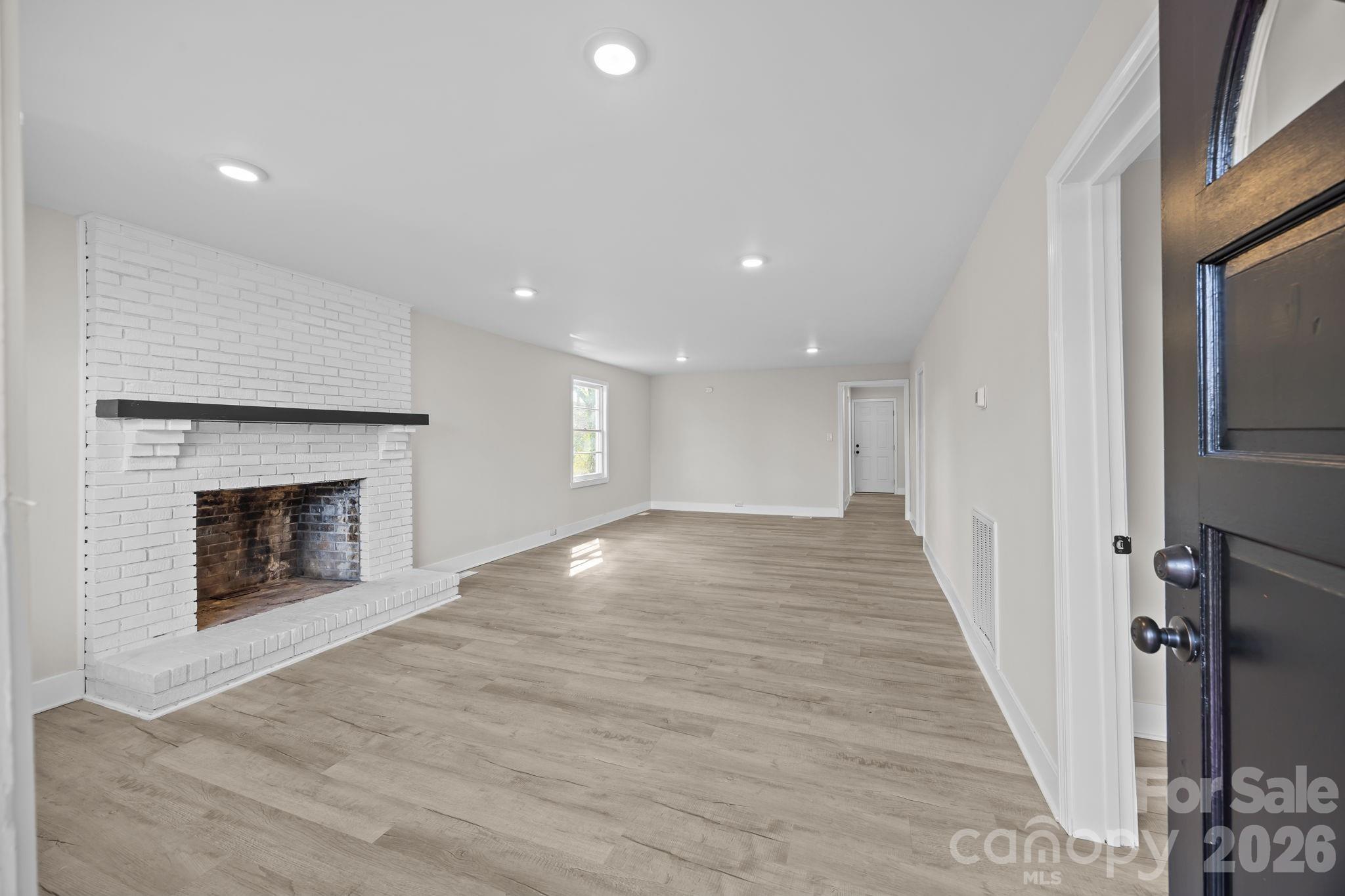 511 East Trade Street Dallas, NC 28034 - Photo 4 of 16 a view of an empty room with wooden floor fireplace and a window