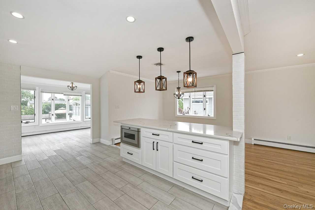 107 Beverly Road Massapequa, NY 11758 - Photo 15 of 41 a view of a kitchen with wooden floor and windows