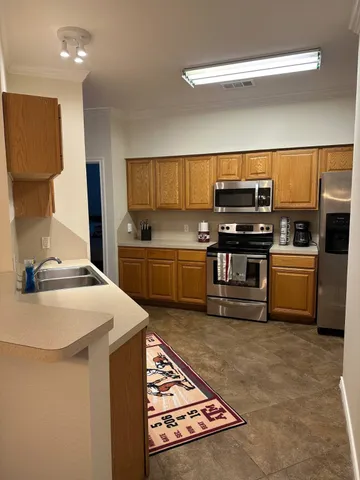 a kitchen with kitchen island granite countertop a sink and cabinets