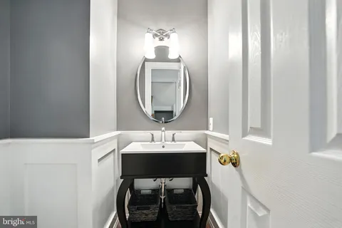 a kitchen with stainless steel appliances granite countertop a refrigerator a stove a sink a dining table and chairs with wooden floor