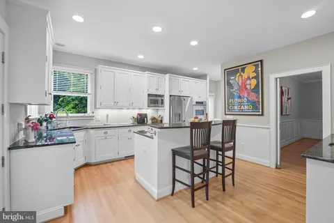 a kitchen with granite countertop a sink stove and cabinets