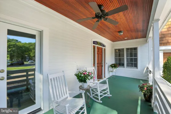 a view of a porch with furniture and a yard