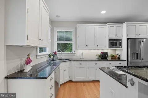 a kitchen with stainless steel appliances granite countertop a stove and a sink
