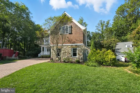 a front view of a house with a yard and trees