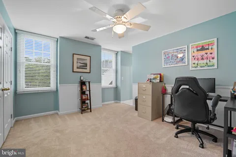 a view of a roof deck with table and chairs under an umbrella with wooden floor