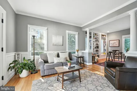a living room with furniture a rug table and a large window
