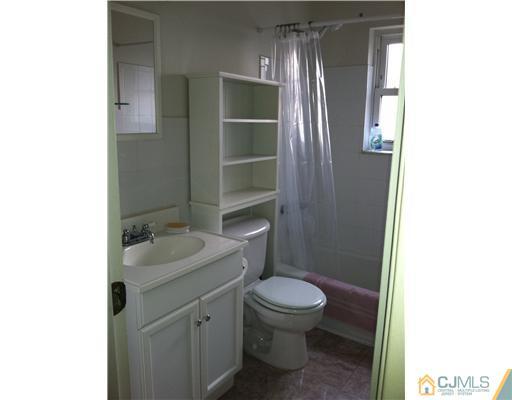 199 Evergreen Road, Unit 13B Edison, NJ 08837 - Photo 13 of 16 a bathroom with a granite countertop toilet a sink and mirror