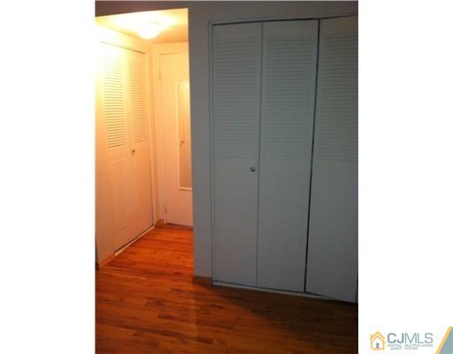 199 Evergreen Road, Unit 13B Edison, NJ 08837 - Photo 14 of 16 a view of an empty room with wooden floor