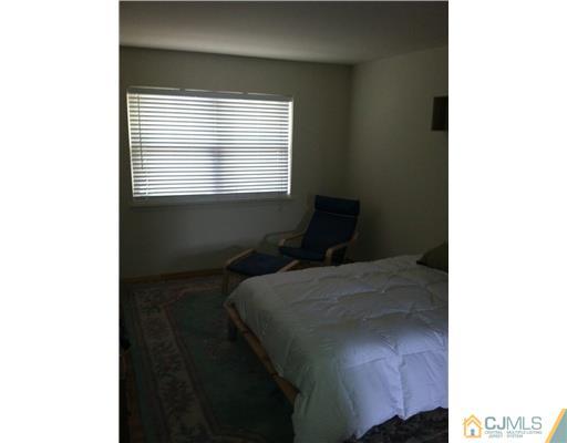 199 Evergreen Road, Unit 13B Edison, NJ 08837 - Photo 10 of 16 a bed sitting in a bedroom next to a window