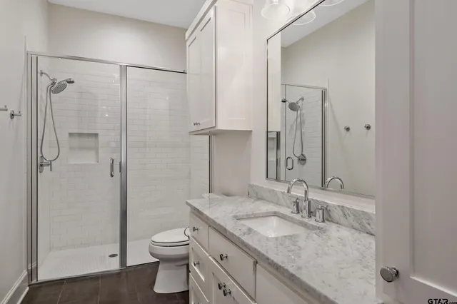 a bathroom with a granite countertop sink toilet and shower