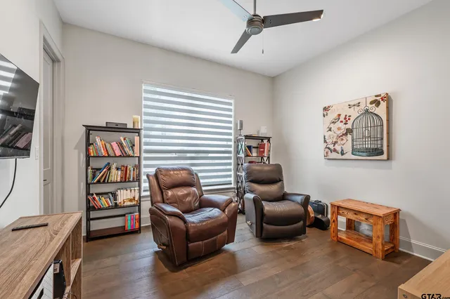 a living room with furniture a ceiling fan and a window
