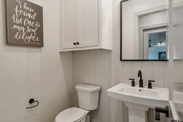 a bathroom with a toilet sink and mirror
