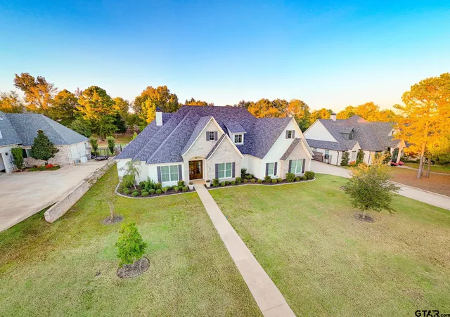 a view of a large house with a big yard and potted plants