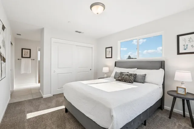 a bedroom with a bed and a painting on the wall