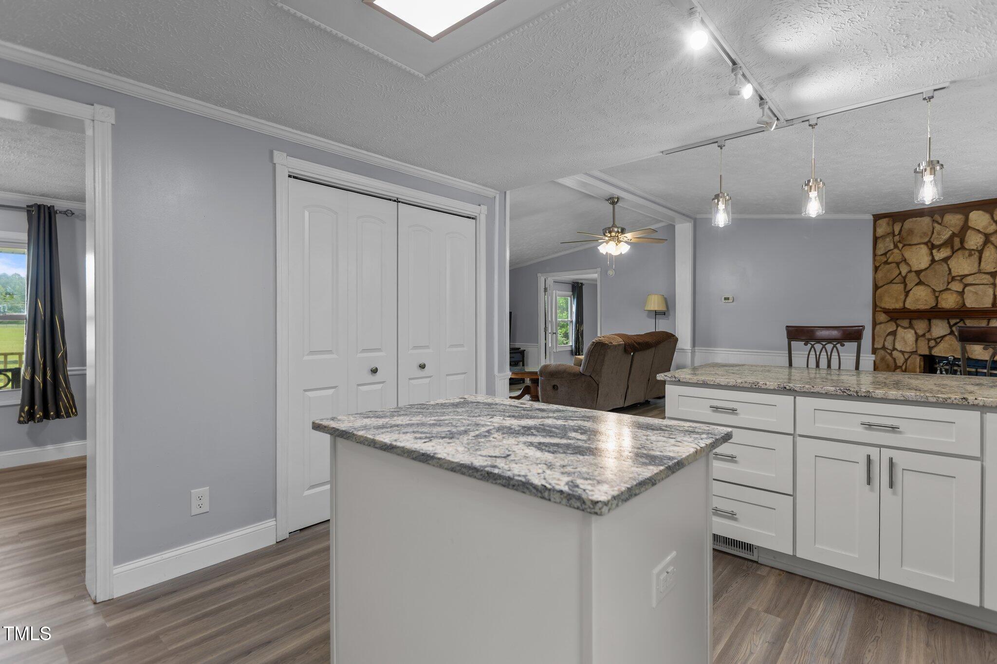 1167 John D Winstead Road Roxboro, NC 27574 - Photo 12 of 55 a kitchen with a sink dishwasher and white cabinets with wooden floor