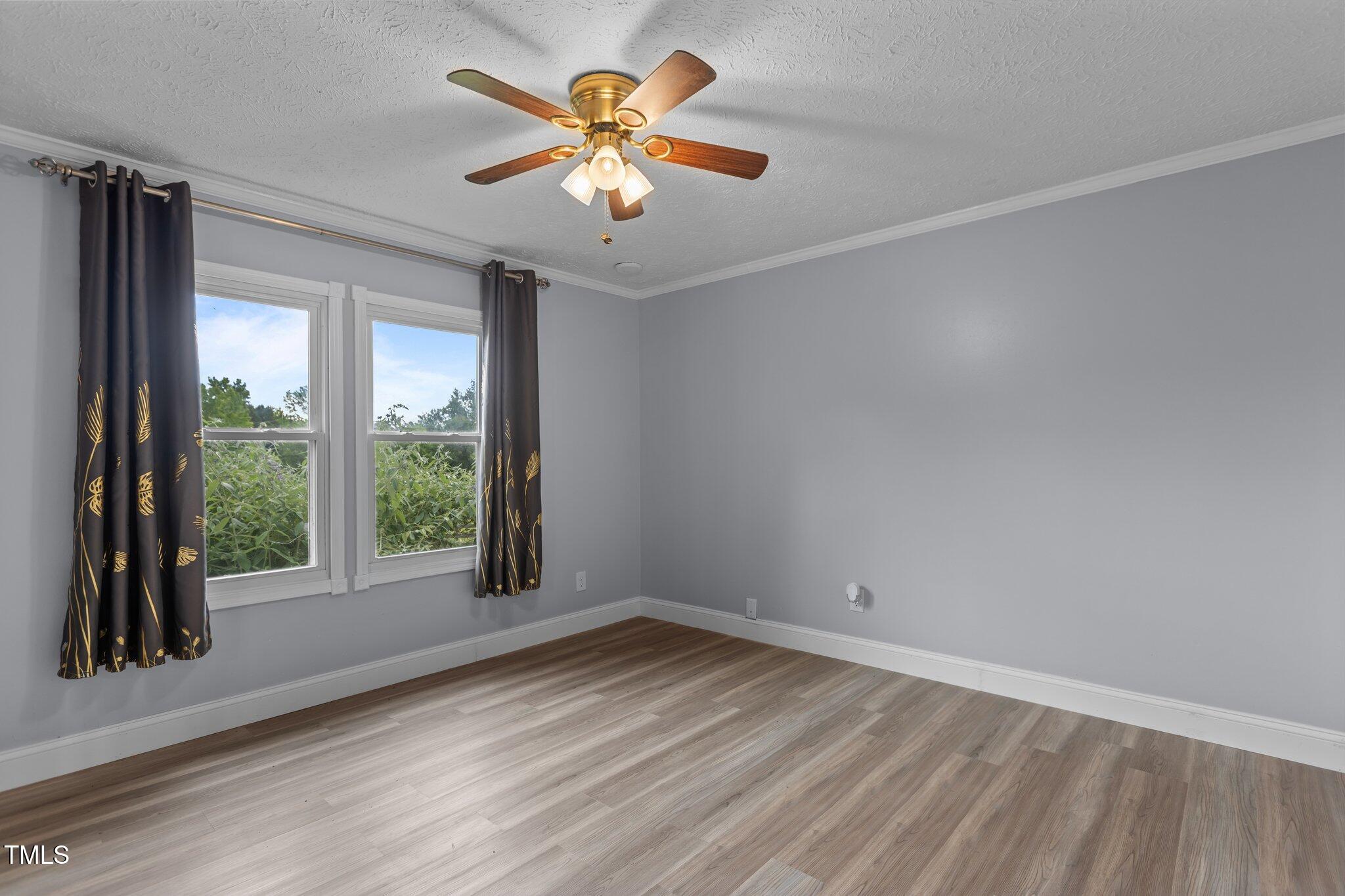 1167 John D Winstead Road Roxboro, NC 27574 - Photo 21 of 55 an empty room with a window and a ceiling fan
