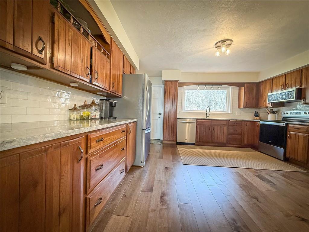 163 Crisswell Road Butler, PA 16002 - Photo 11 of 46 a kitchen with stainless steel appliances granite countertop a sink stove and wooden cabinets