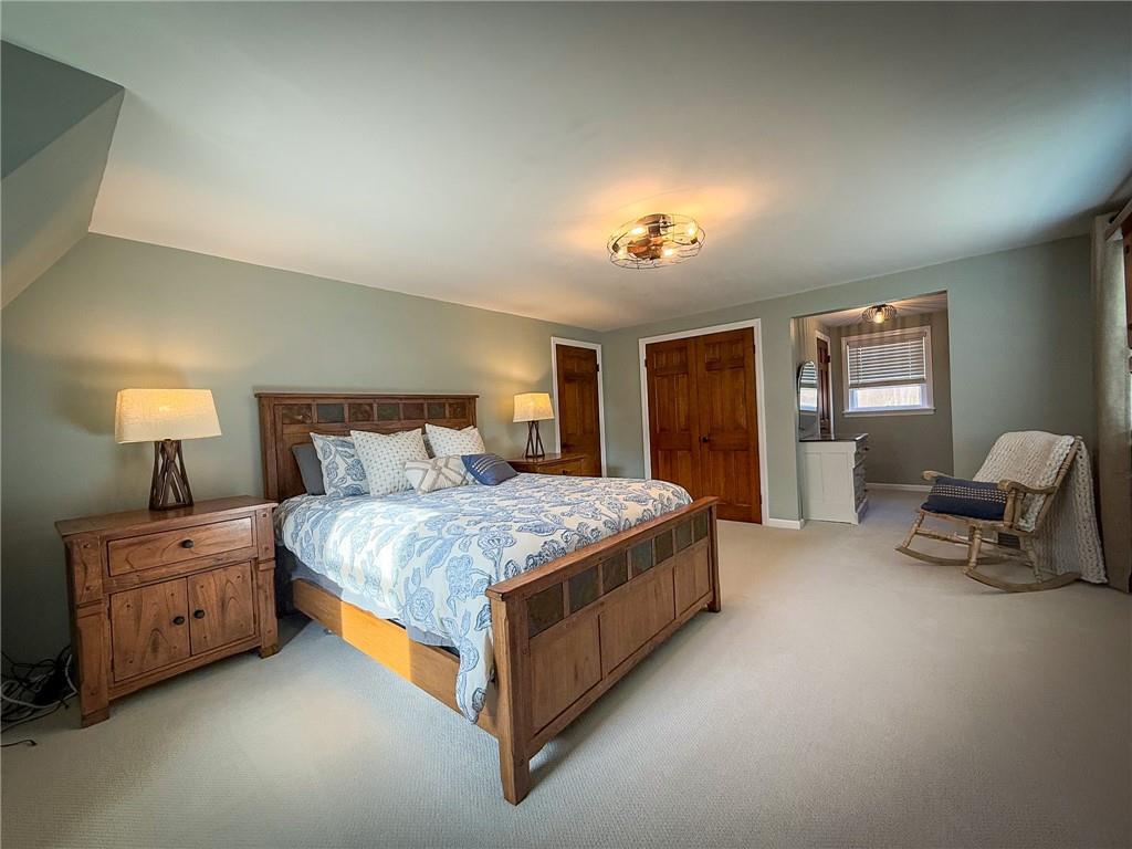 163 Crisswell Road Butler, PA 16002 - Photo 26 of 46 a spacious bedroom with a bed and a chandelier
