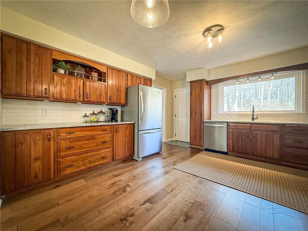 163 Crisswell Road Butler, PA 16002 - Photo 8 of 46 a kitchen with granite countertop a stove a sink and a refrigerator