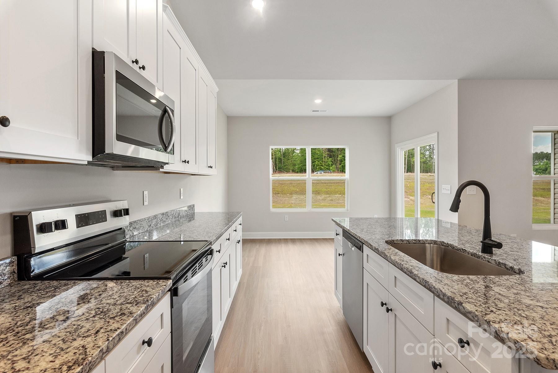 7015 Jerimoth Drive Charlotte, NC 28215 - Photo 4 of 9 a kitchen with stainless steel appliances granite countertop a sink stove and oven
