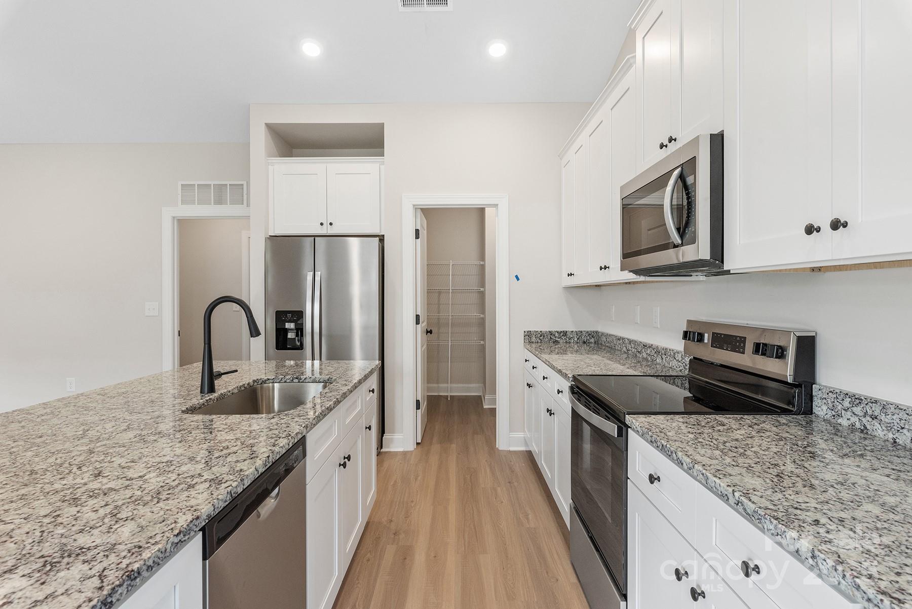 7015 Jerimoth Drive Charlotte, NC 28215 - Photo 5 of 9 a kitchen with stainless steel appliances granite countertop a stove and a sink