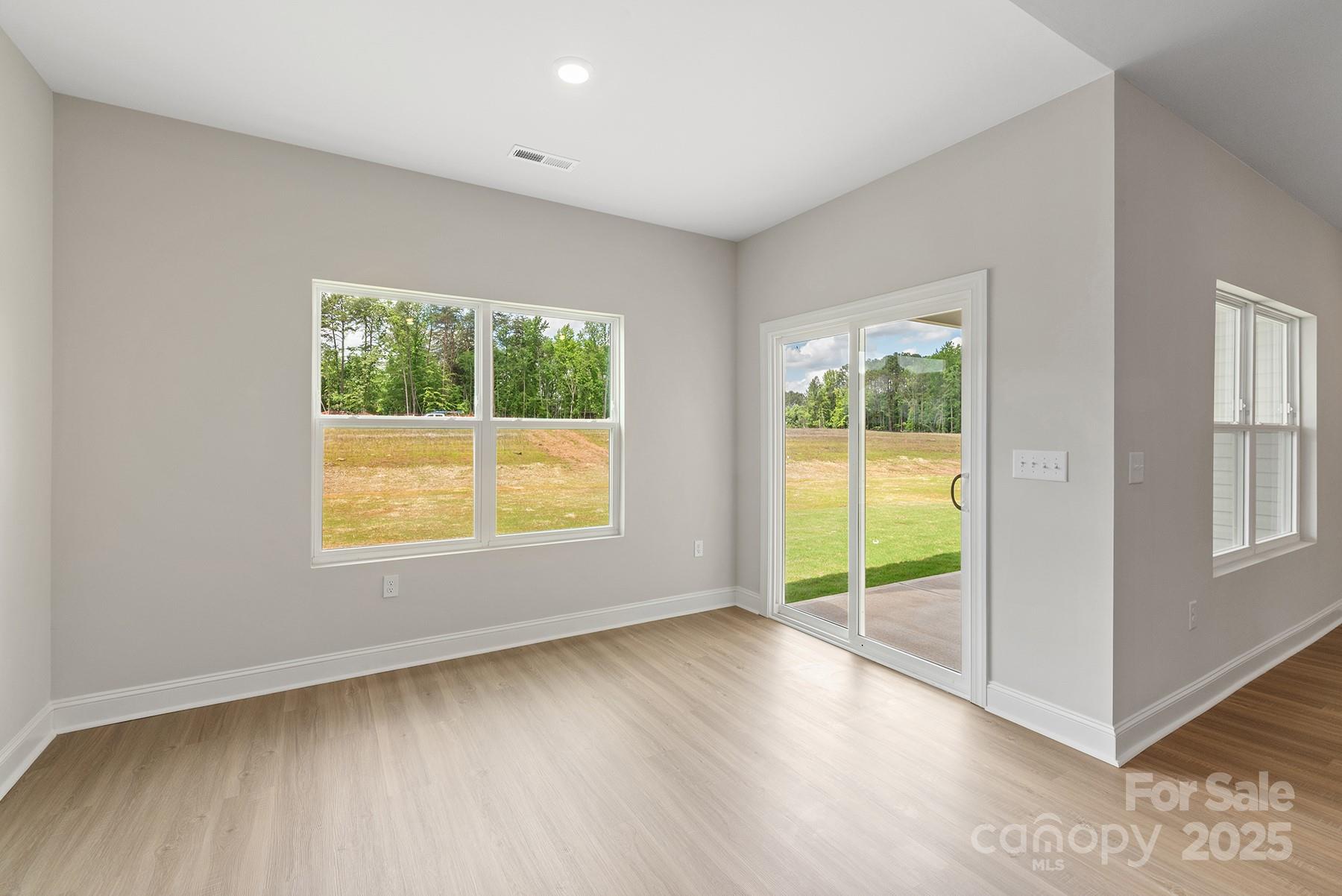 7015 Jerimoth Drive Charlotte, NC 28215 - Photo 7 of 9 an empty room with wooden floor and windows