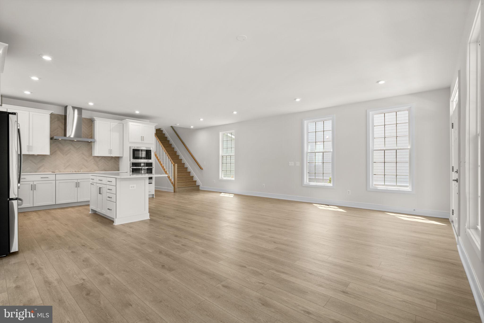 1013 Captain Richards Court Marshall, VA 20115 - Photo 14 of 44 an empty room with wooden floor and a kitchen
