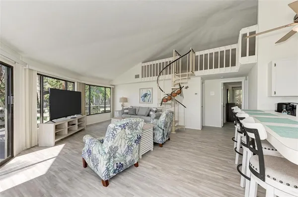 a living room with furniture large window and wooden floor