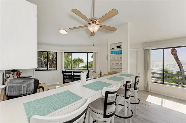 a kitchen that has a lot of white cabinets and stainless steel appliances