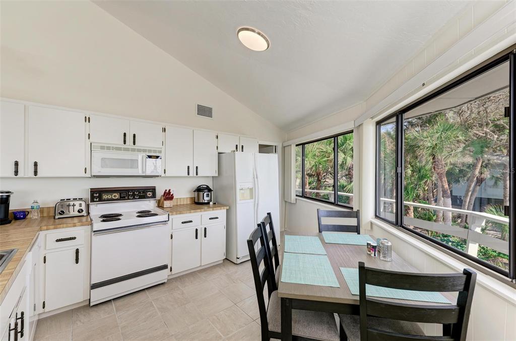 6590 Manasota Key Road Englewood, FL 34223 - Photo 20 of 69 a kitchen that has a lot of white cabinets and stainless steel appliances