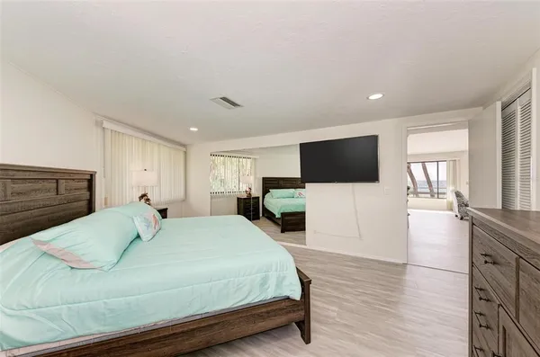 a bedroom with a bed and wooden floor